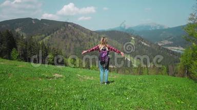 一个年轻的高加索女<strong>人</strong>带着背包和太阳镜<strong>站在山顶</strong>上举起双手。 概念